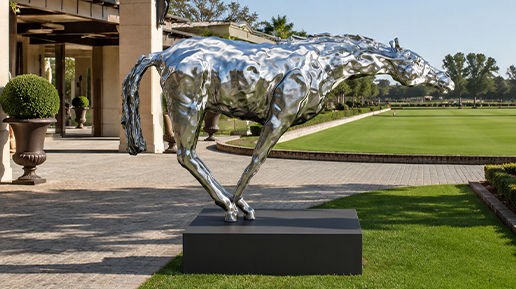 Sculpture contemporaine de cheval en finition miroir installée dans un jardin extérieur