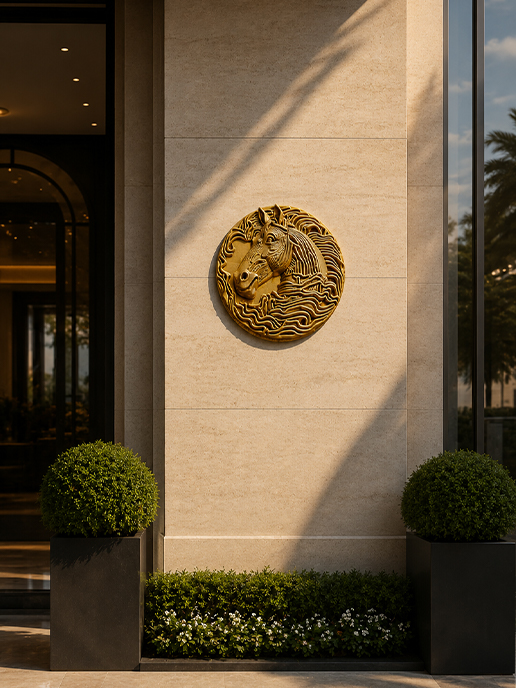 Sculpture murale ronde représentant une tête de cheval dorée sur une façade contemporaine